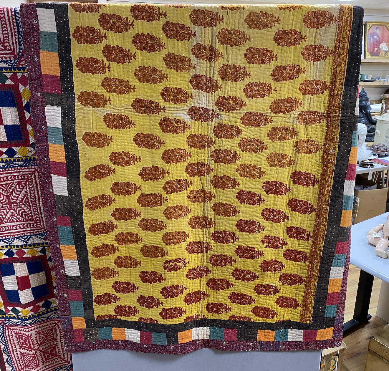 An Indian early 20th century multicoloured fabric quilt, with an embroidered central panel and printed cotton border, 115cm wide, 192cm long